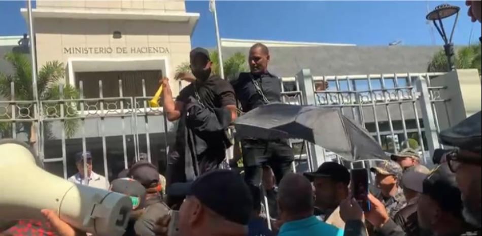Agentes pensionados se encadenan frente al Ministerio de Hacienda