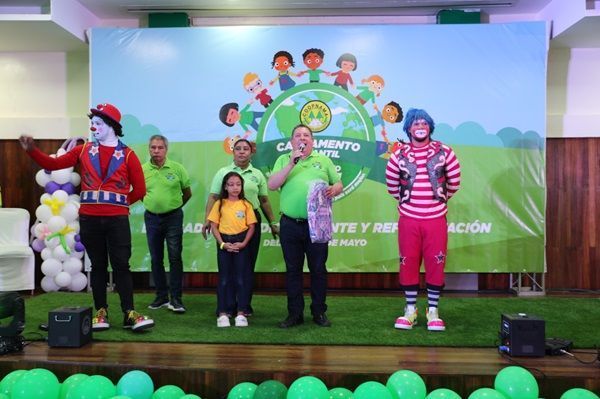 Prof. Santiago Portes entrega un obsequio a niña participante al Campamento Infantil de Verano.