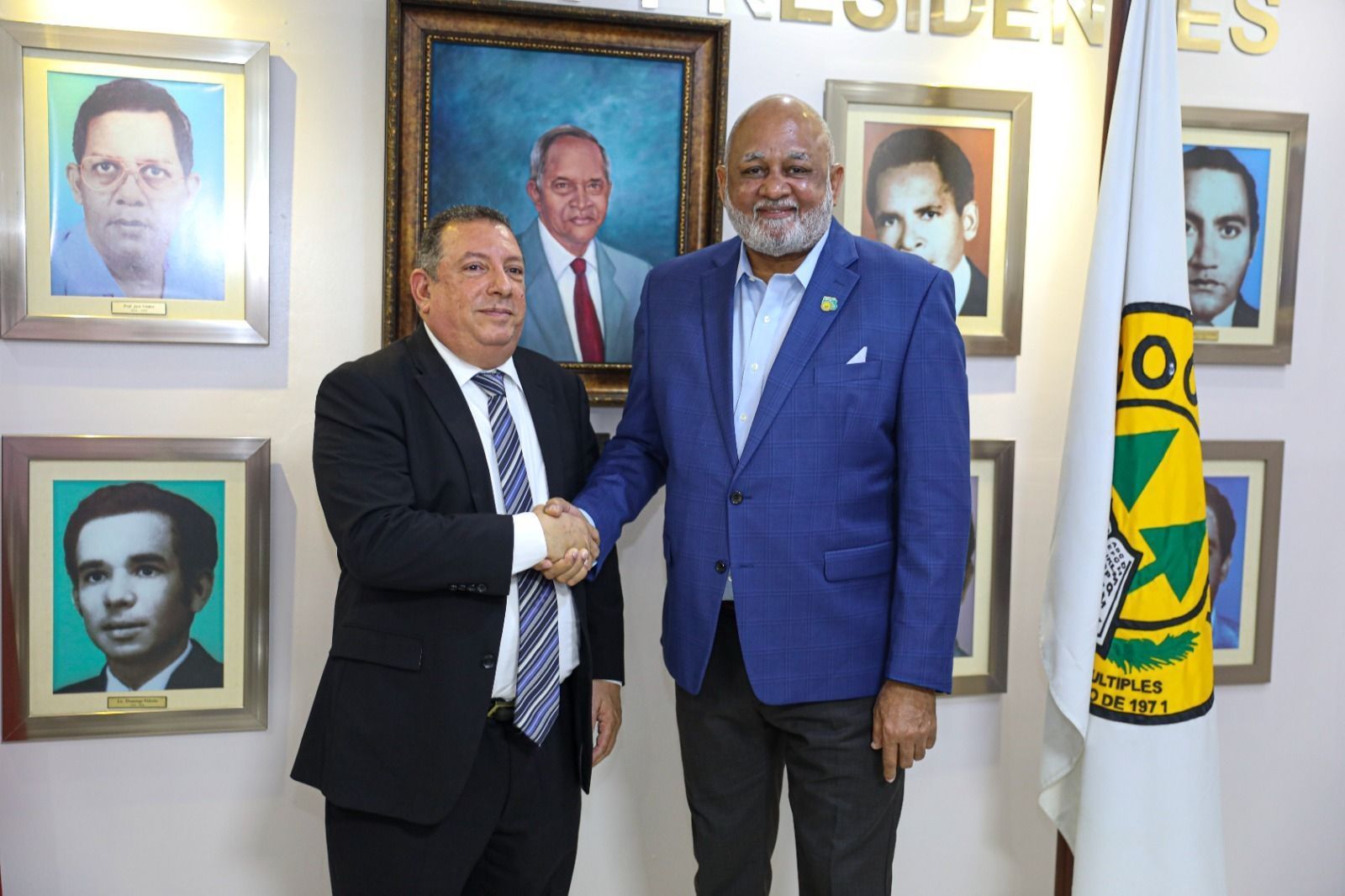 El presidente del Consejo de Administración de COOPNAMA, profesor Santiago Portes mientras saluda al Dr. Roberto Fulcar.
